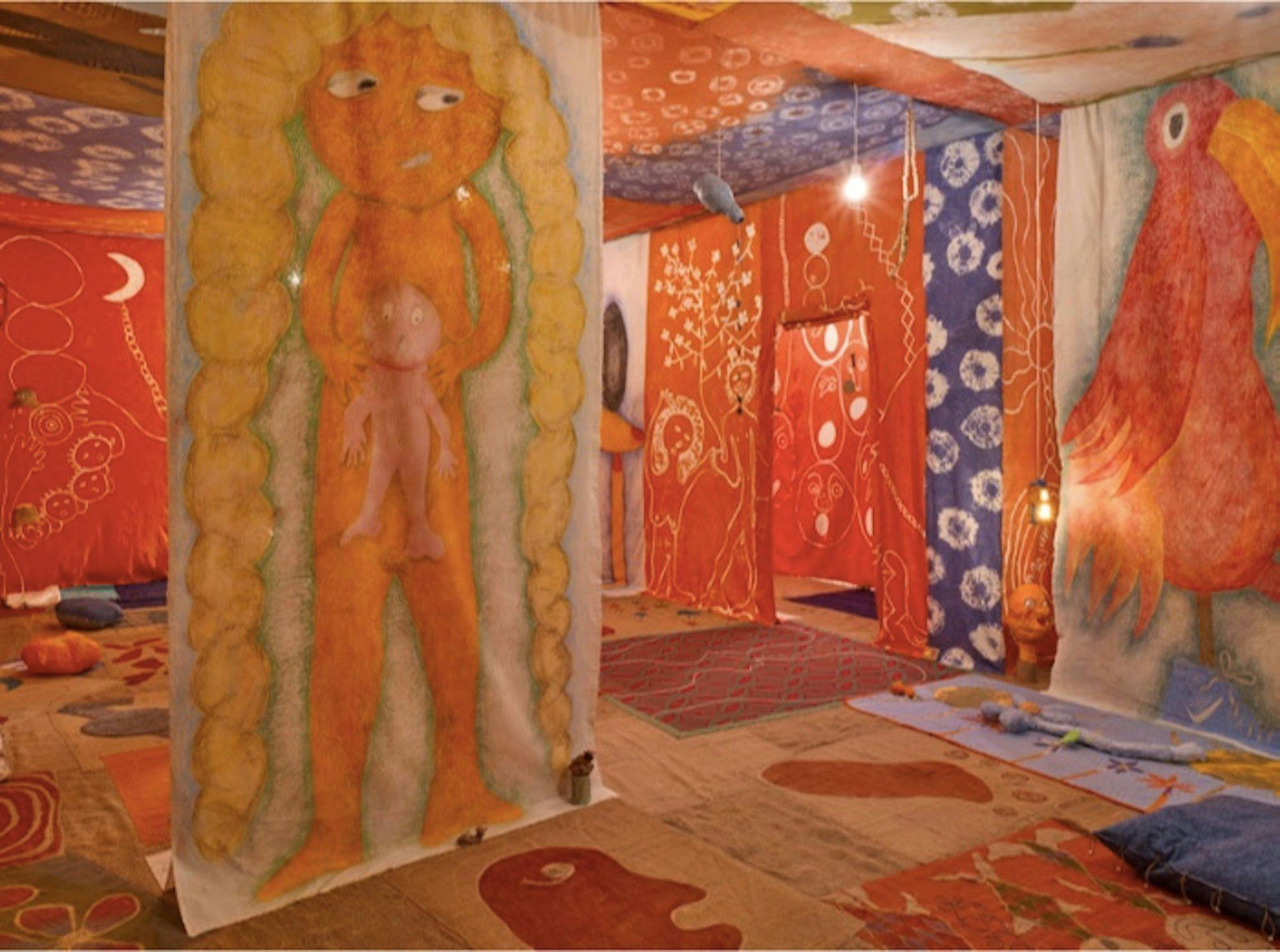 A room filled floor to ceiling with warm-toned carpets and tapestries.